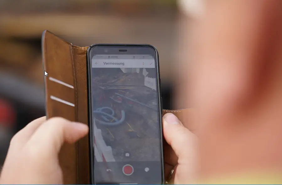 Guido Reimuth mit der Augmented Reality-Vermessung per Smartphone mit Vaira auf einer Baustelle.