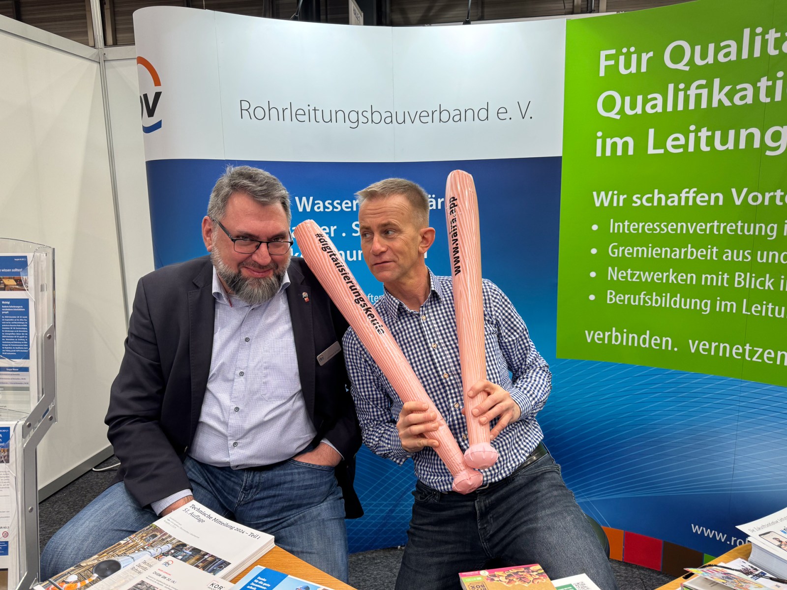 Christoph Kreutz und Helge Fuchs vom Rohrleitungsbauverband e.V. schwingen die Digitalisierungskeule von Vaira.
