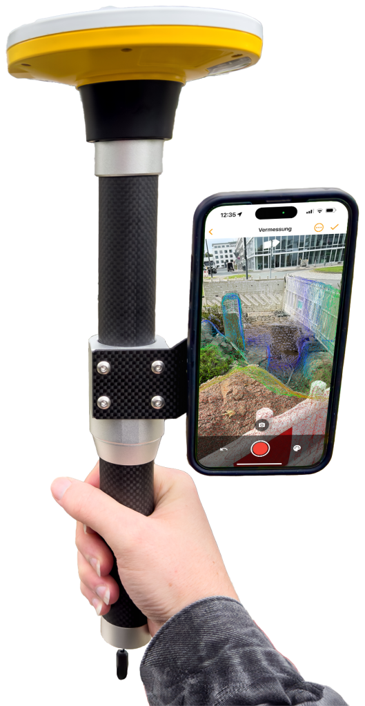 Produktfoto einer Trimble DA2-Antenne mit befestigtem Smartphone. Auf dem Smartphone ist die Vermessung mit Vaira zu sehen. Im Vermessungsbild ist zudem die typische Gitternetzstruktur der LiDAR-Umgebungserkennung mit der Vaira App zur präzisen Vermessung zu sehen.