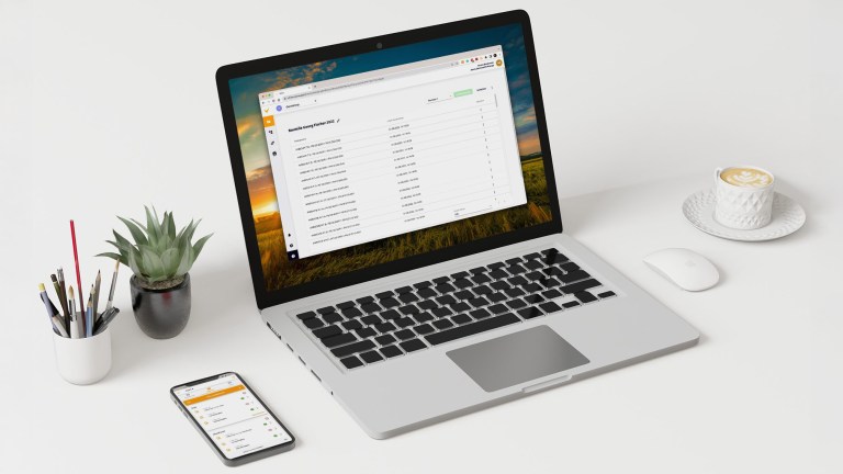 Darstellung eines Laptops und eines Smartphones mit einiger Dekoration (Pflanze, Stifte, Kaffeetasse) auf einer weißen Fläche. Auf dem Smartphone ist die Vaira App geöffnet, auf dem Laptop das Vaira Office. In der Vaira App ist die Aufgaben-Übersicht geöffnet, im Vaira Office ist die Vorgangsliste zu sehen.