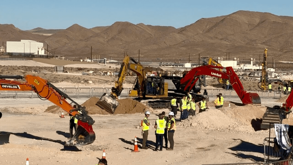 Eine Großbaustelle in Amerika, auf der einige Monteure miteinander sprechen.