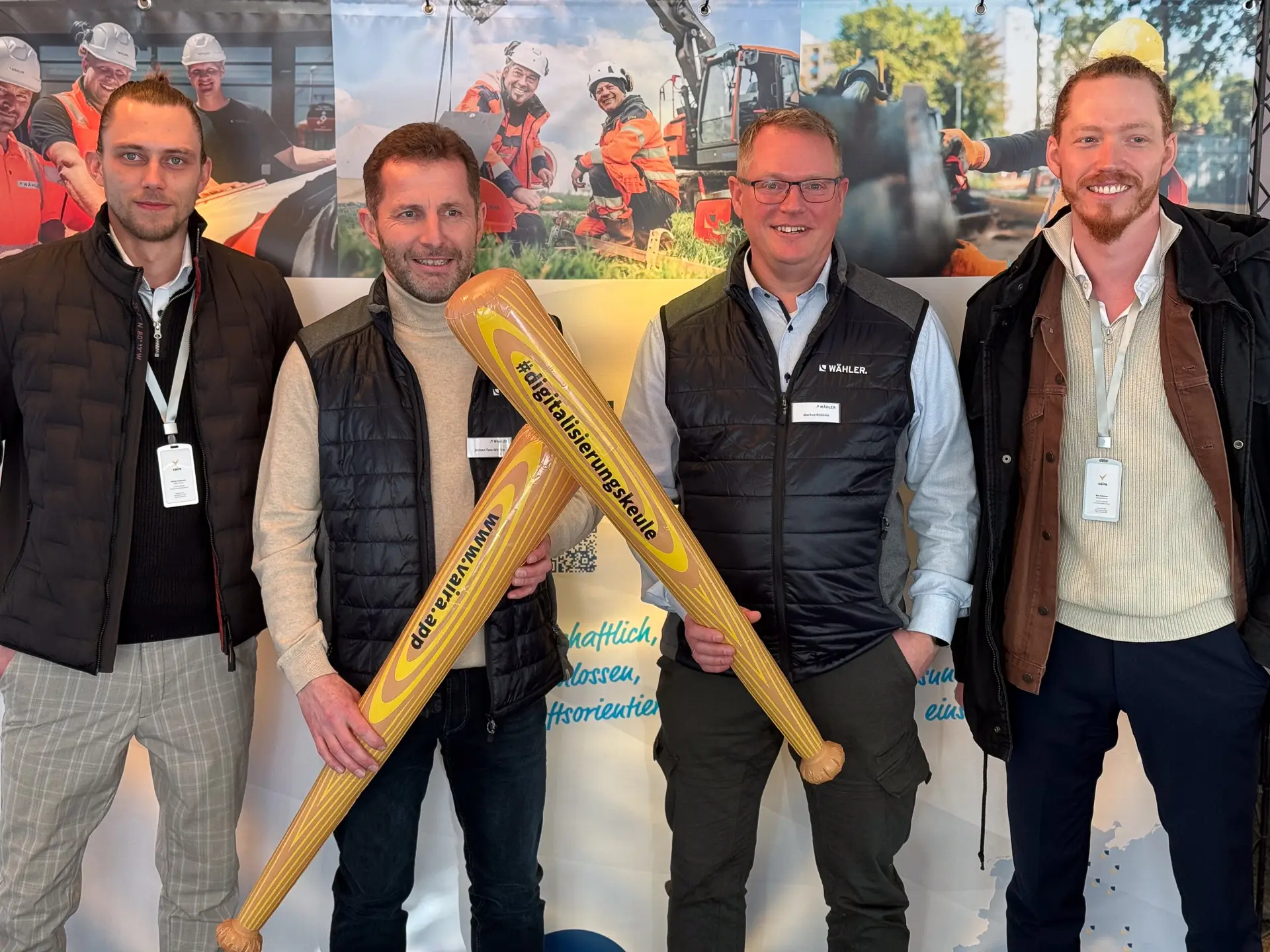 Gruppenfoto – (v.l.) Philipp Buttmann (Vaira), Jochen Tom Wörden (WÄHLER), Markus Kühlcke (WÄHLER) und Max Erdmann (Vaira) am Stand von WÄHLER auf der IRO 2025. Jochen und Markus halten eine Digitalisierungskeule von Vaira in der Hand.