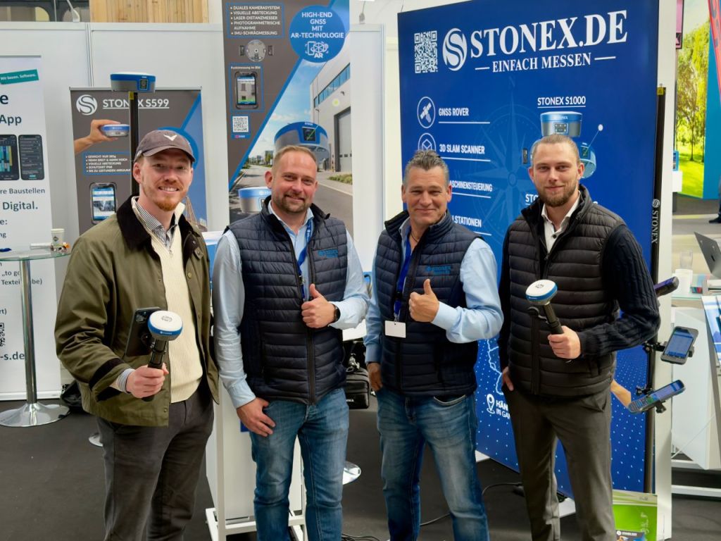 (v.l.) Max Erdmann, Stefan Werner, Thomas Schmitt und Philipp Buttmann am Messestand von Stonex auf der NordBau 2026. Max und Philipp halten eine Stonex S599 in der Hand, Stefan und Thomas halten einen Daumen in die Kamera.